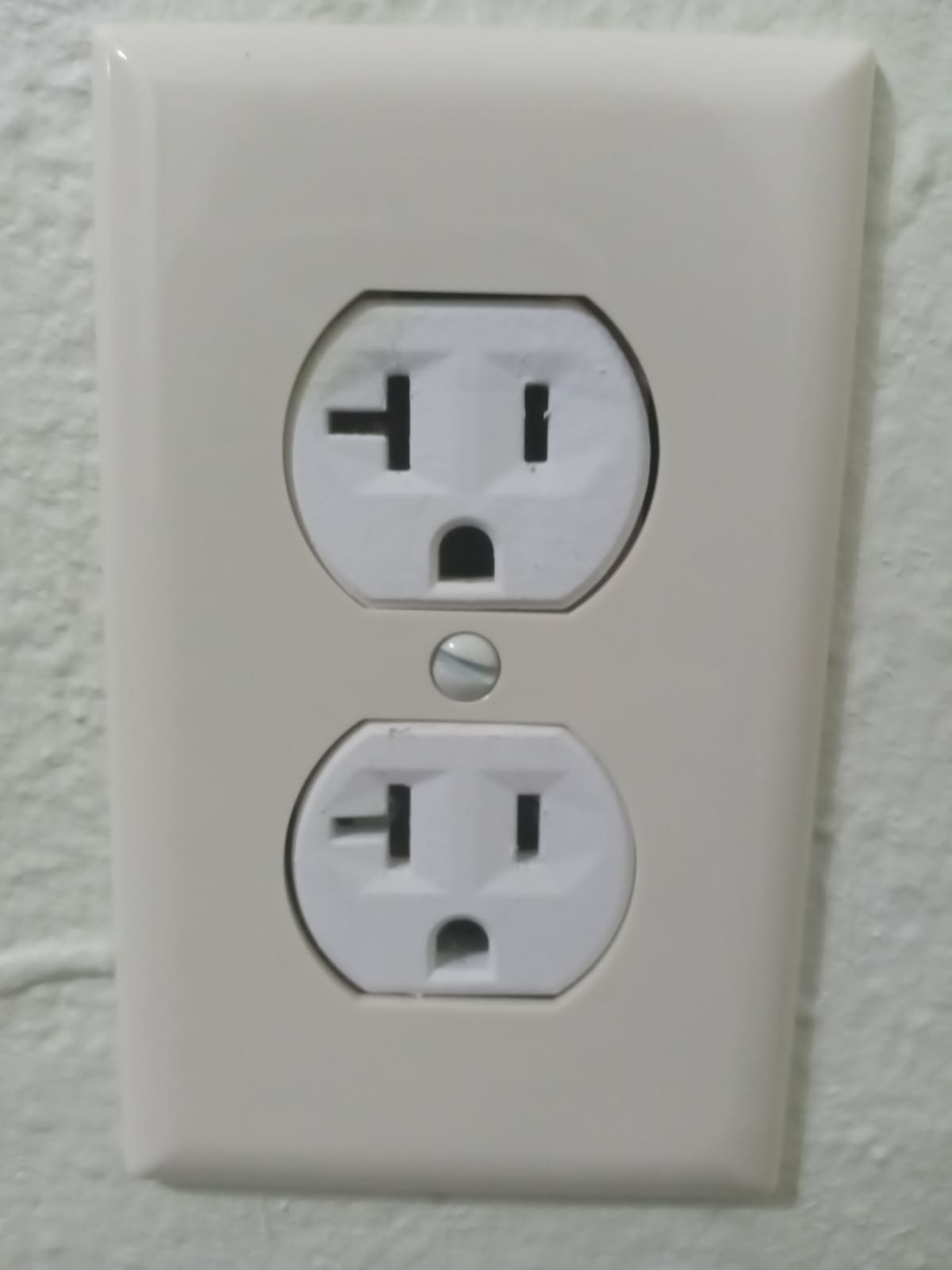 Tomada elétrica de parede com fiação interna visível